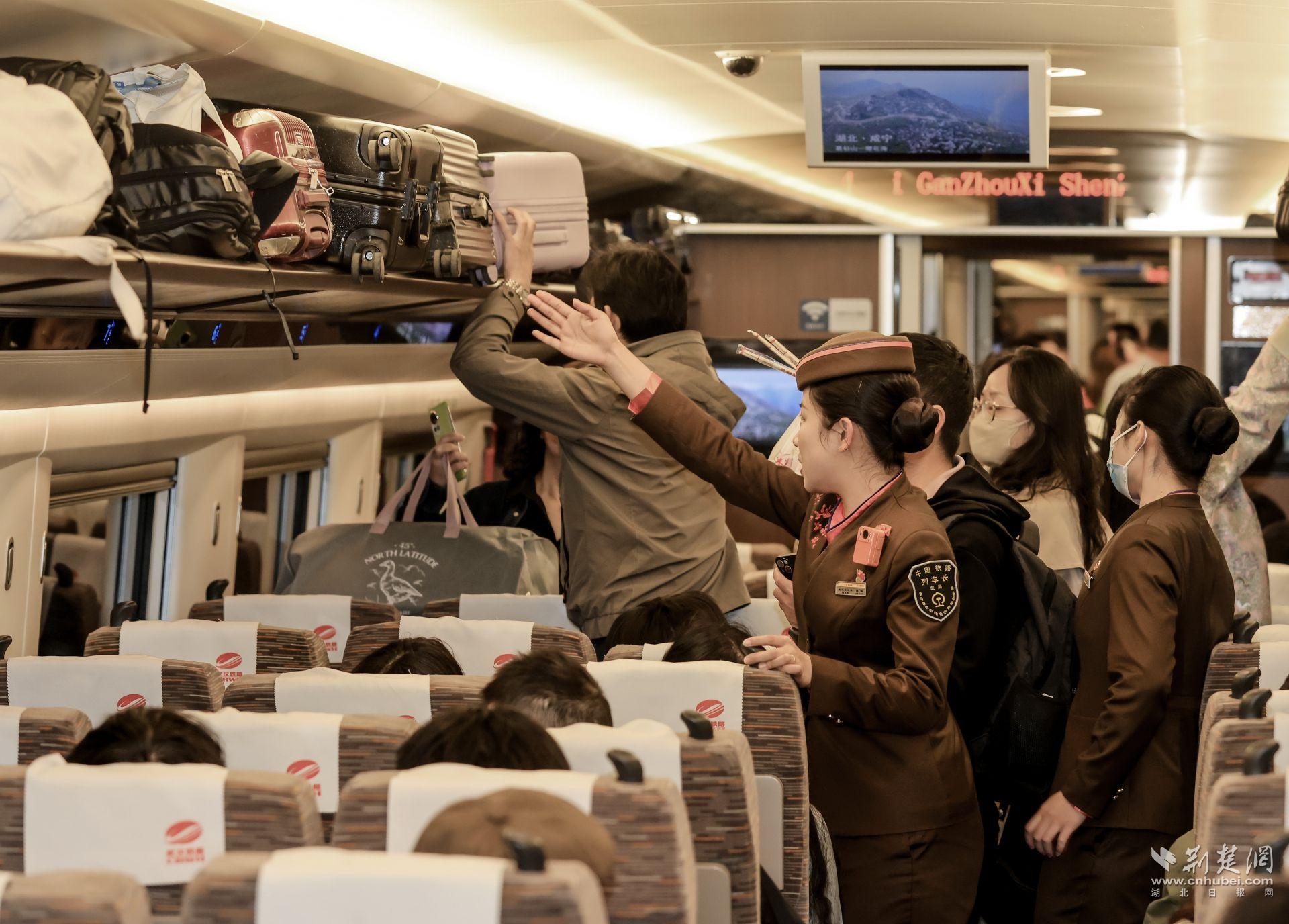 5月1日，武漢客運段G380次列車長孫暢幫助旅客整理行李.jpg.jpg