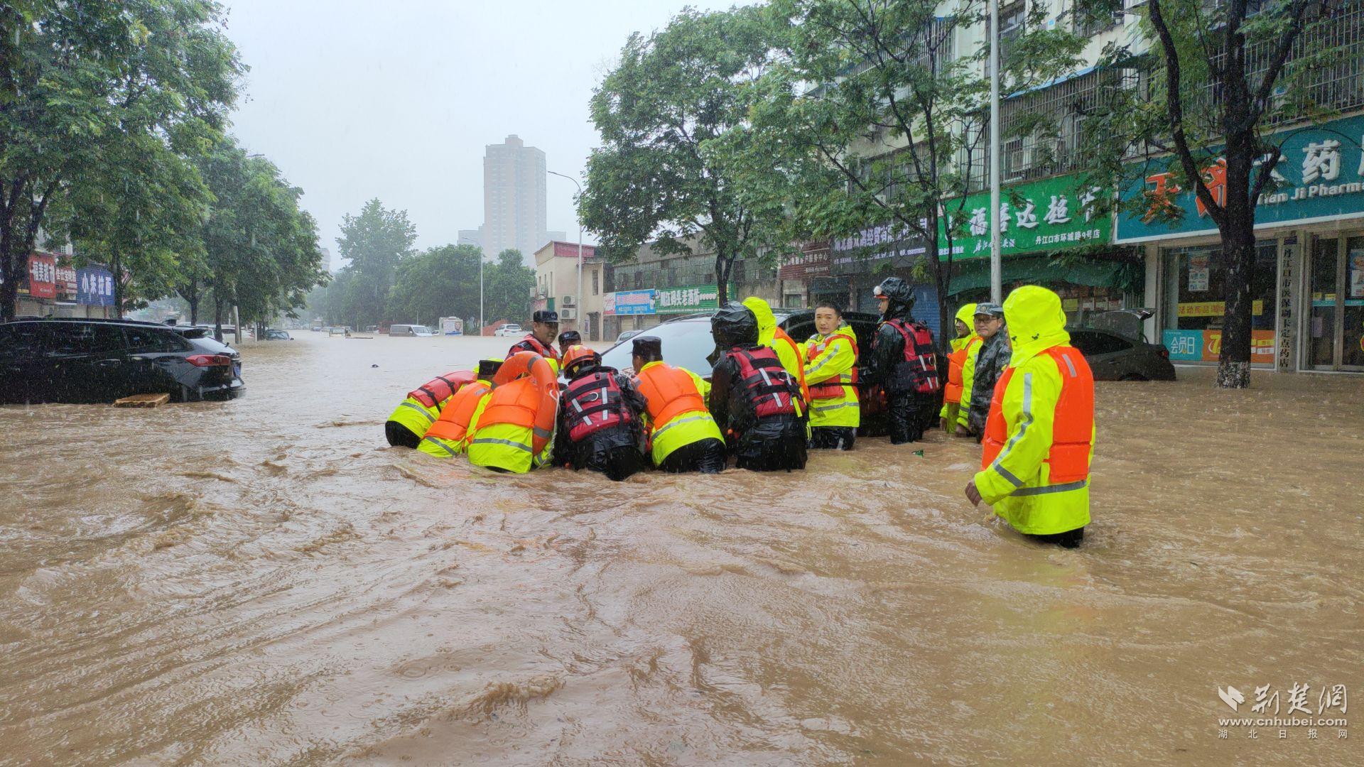 7月14日，湖北省丹江口市城區(qū)路面大面積嚴重積水，一輛黑色SUV轎車被洪水沖至馬路中央無法動彈。為最大程度減少群眾損失，當(dāng)?shù)孛窬? data-origin-src=