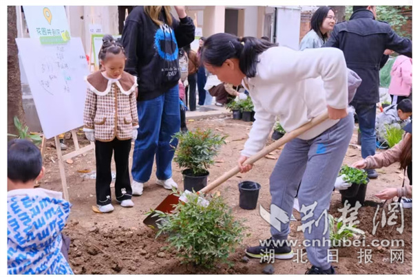 在友友花園中，家長(zhǎng)帶領(lǐng)小朋友種下自己認(rèn)領(lǐng)的花卉.jpg